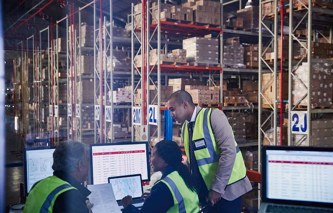 Manufacturing employees discussing benefits in from of computers