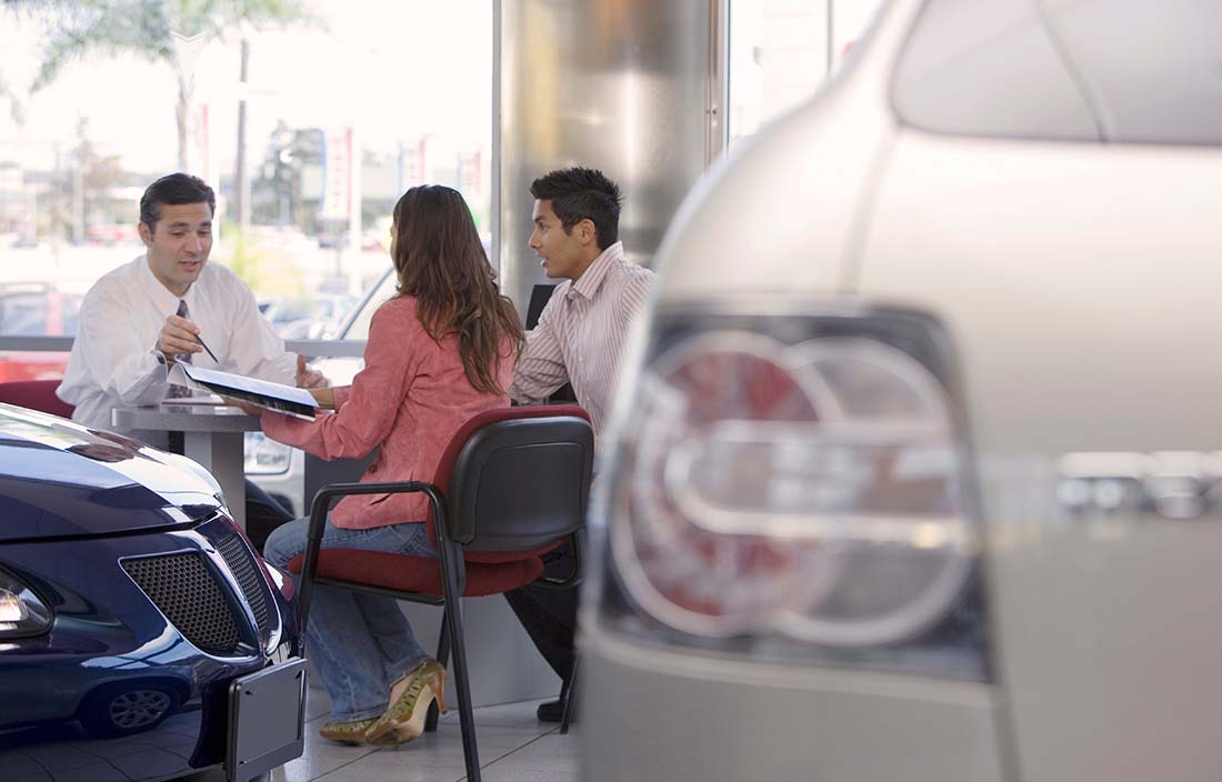 Dealership tax reform discussed by three people at a desk