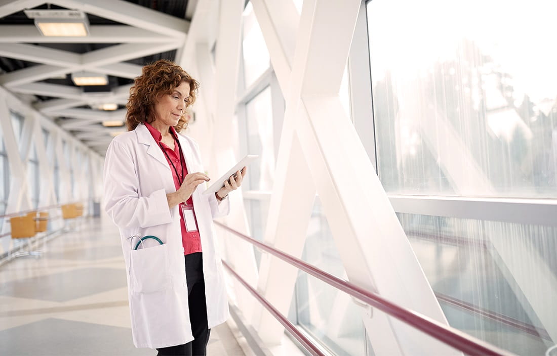 Image of a female doctor reviewing information on a tablet computer.