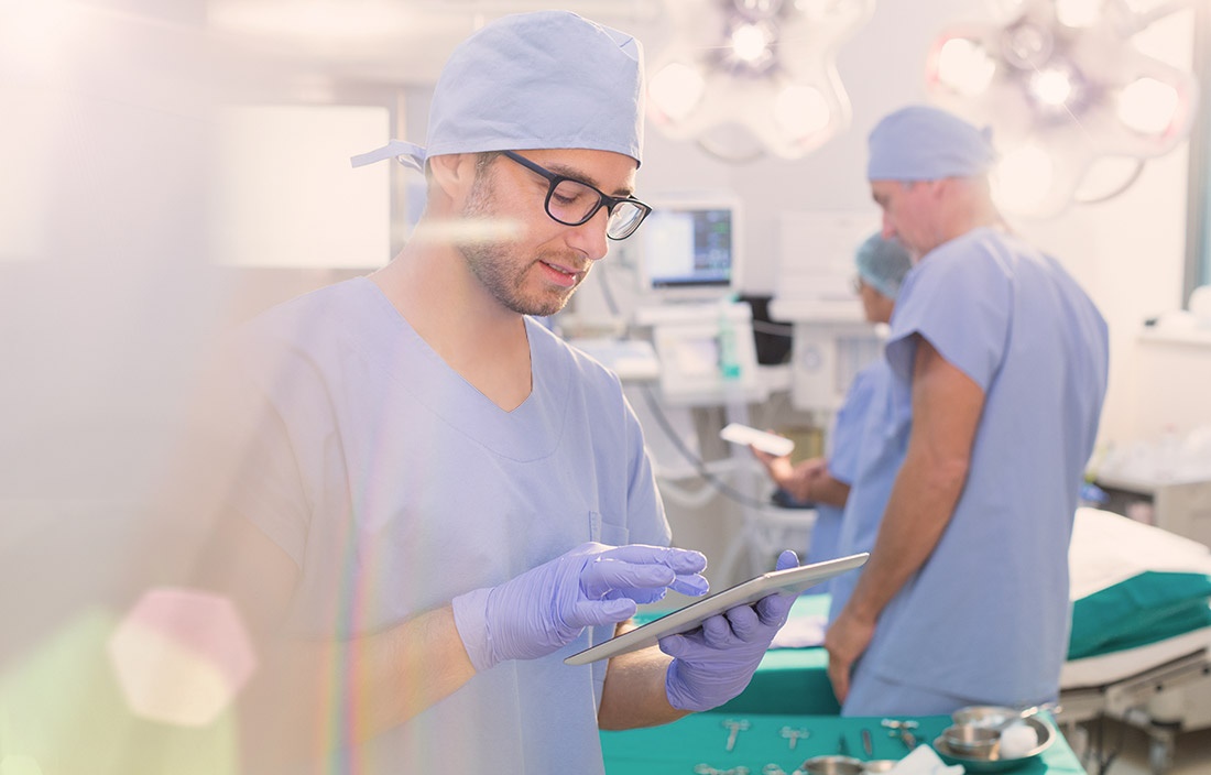 Image of surgeon in blue scrubs in an operating room.