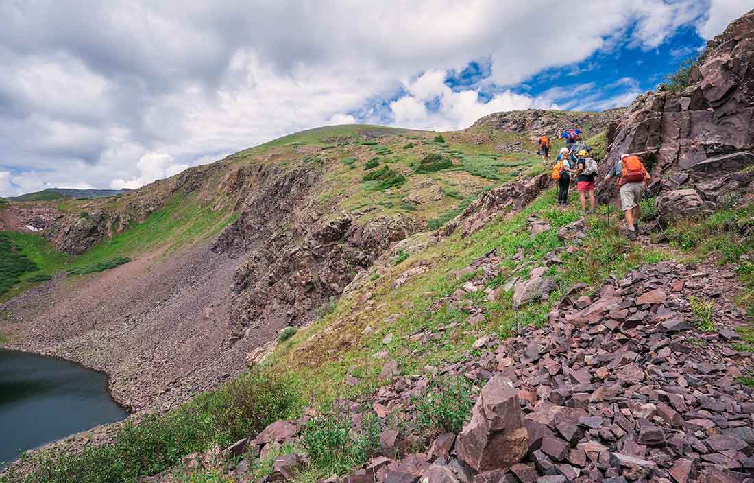 Image of people hiking small mountain.