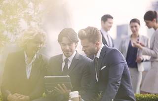 Business colleagues using an iPad to read about Section 1231.