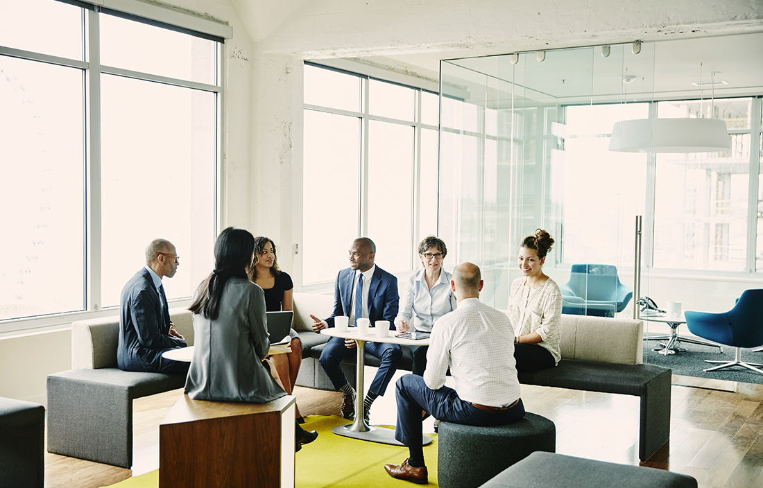Group of younger staff members in a company meeting in a casual lounge for a meeting.