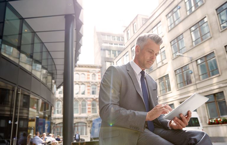 Business professional with iPad on street