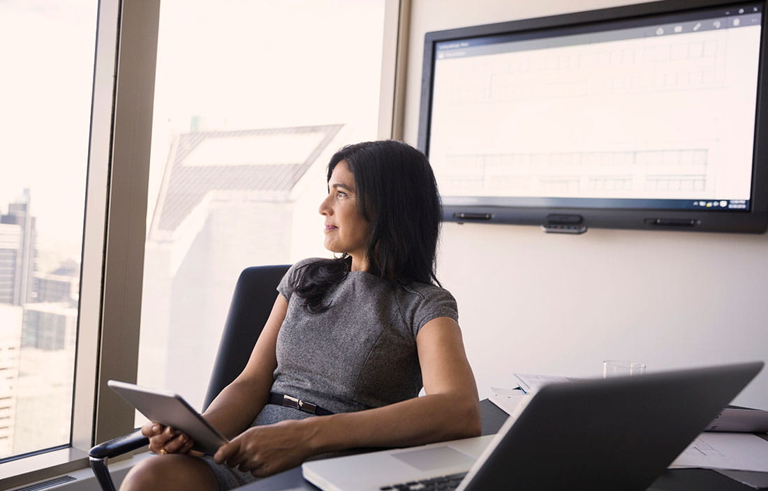 Woman sitting at desk looking out the window