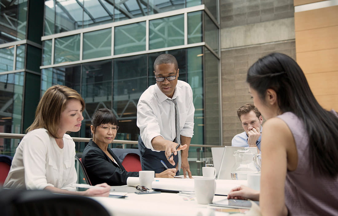 Multiple people sitting at a table looking at plans