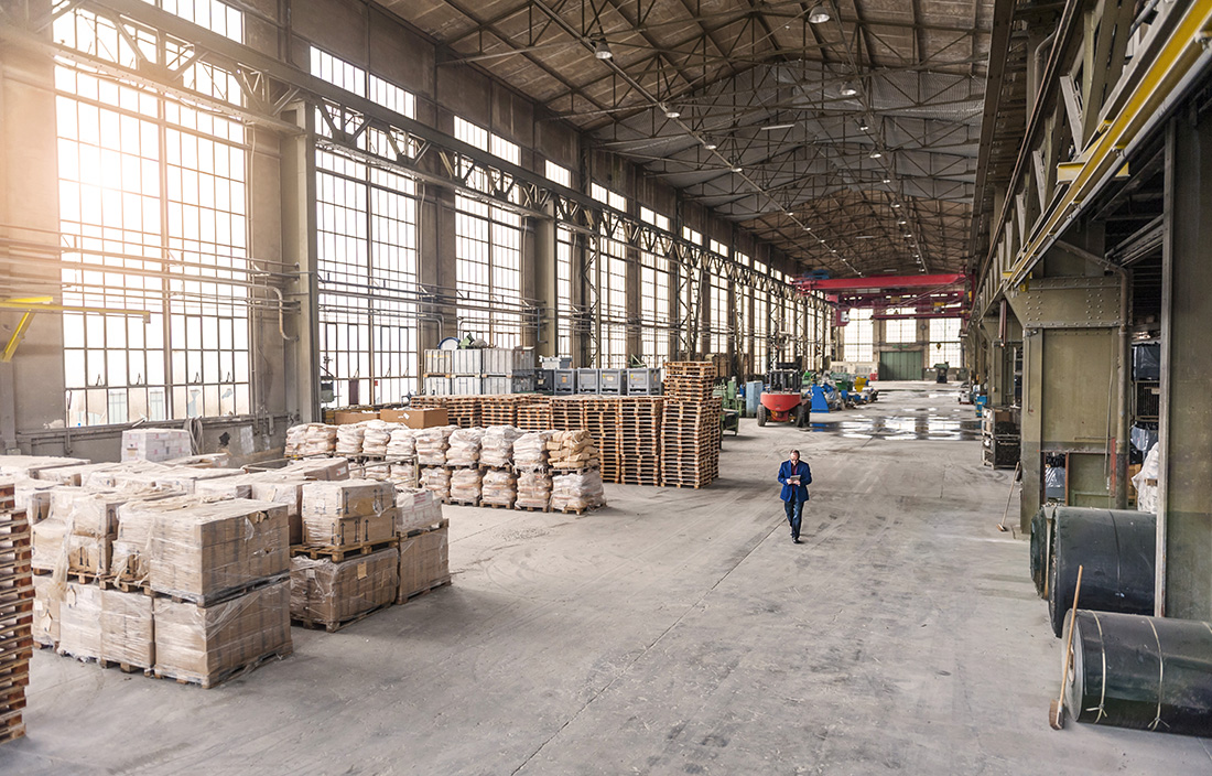 Photo of a warehouse with loading docks and workers walking around. 