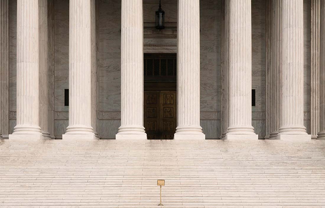 Steps leading up to a government building with column supports.
