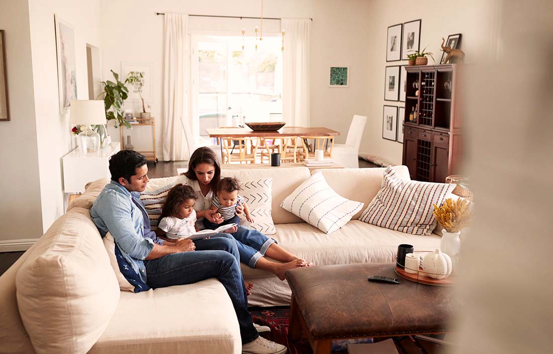 A family sitting on the couch reading