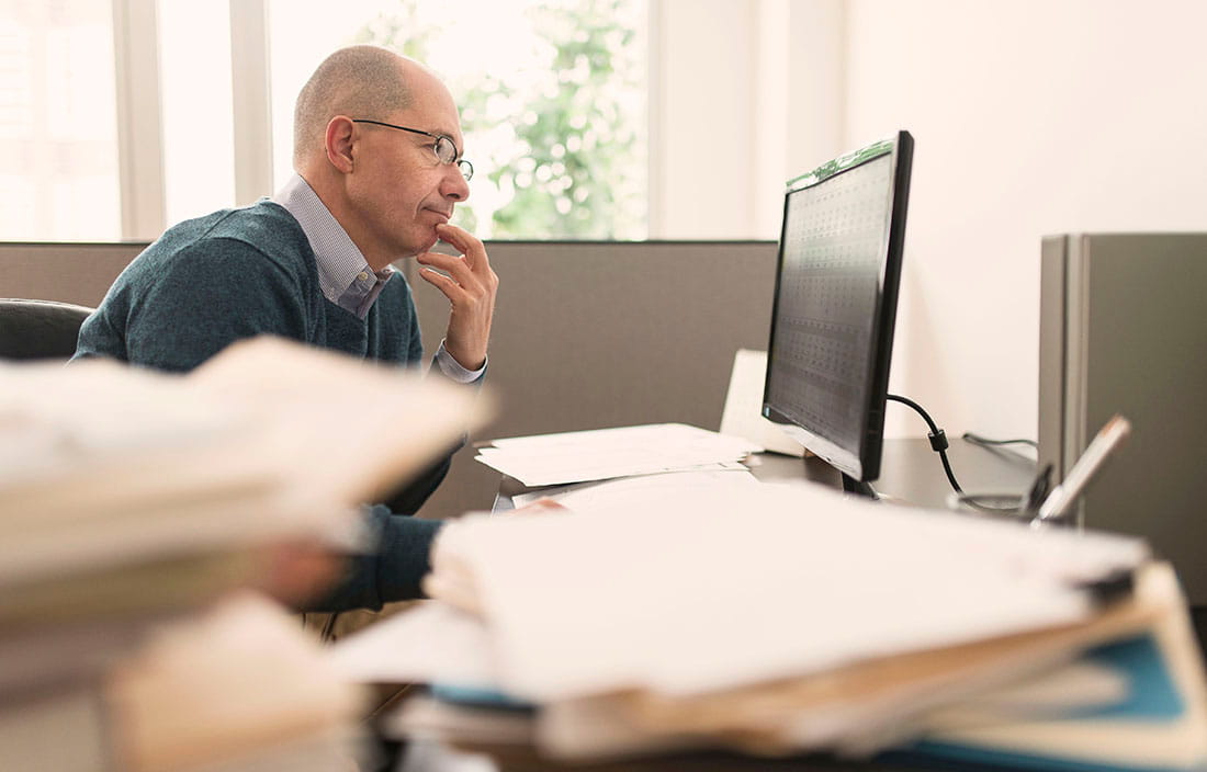 Man using computer at his desk to read about Canadian COVID-19 wage subsidy.