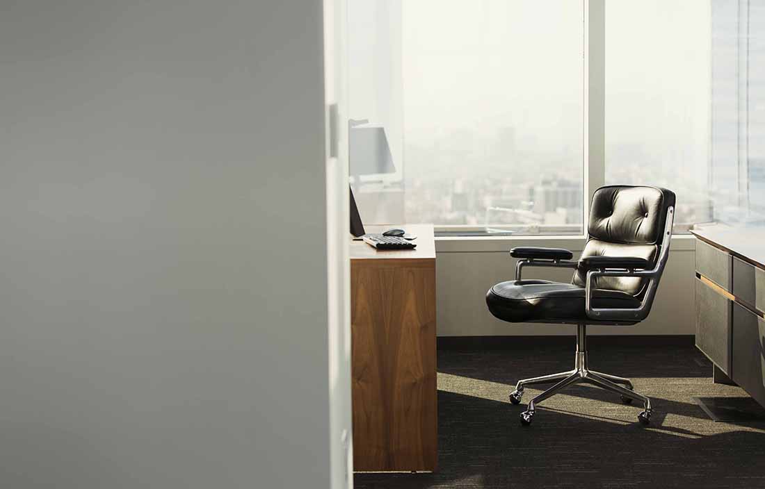 Empty desk and chair in a glass office