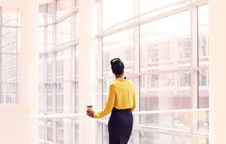 Municipal worker taking a break in a lobby area looking outside the building.