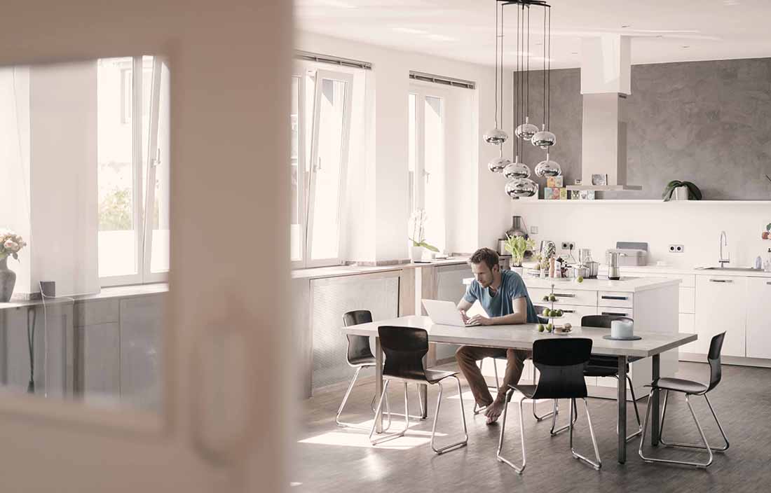 Man sitting at a kitchen table on his laptop