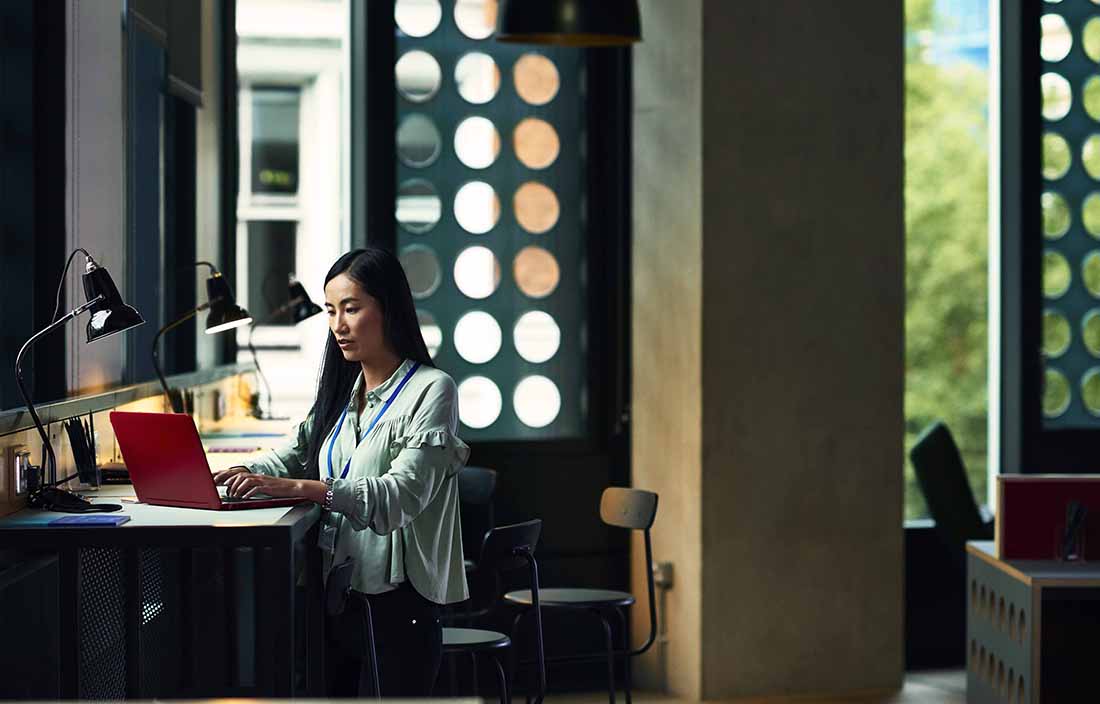 Woman sitting in an open office on her laptop