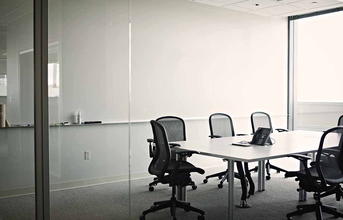An empty conference room with chairs lining a conference table.