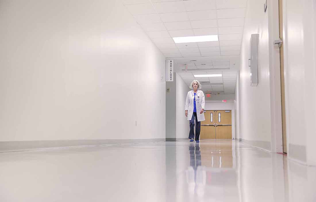 Healthcare worker walking down a hospital hallway