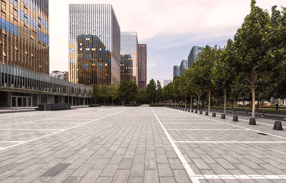 View of an empty parking lot with business buildings nearby.