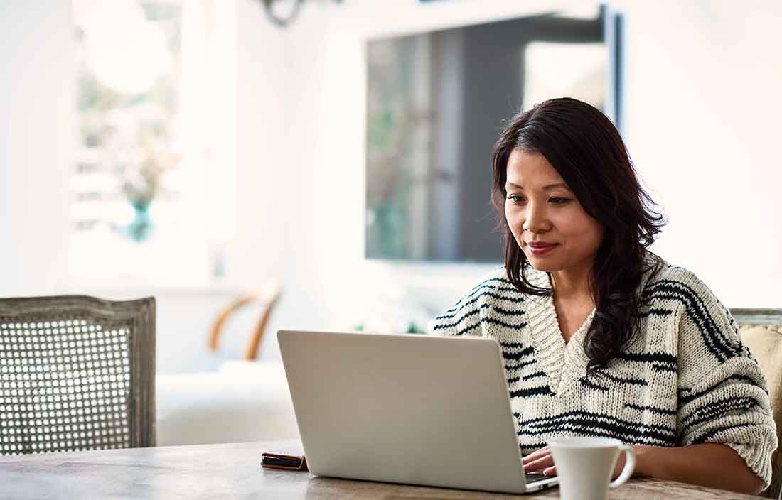 Woman sitting at a table on her laptop