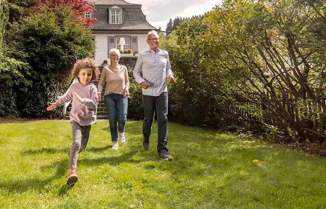 A man, woman, and child playing in a yard