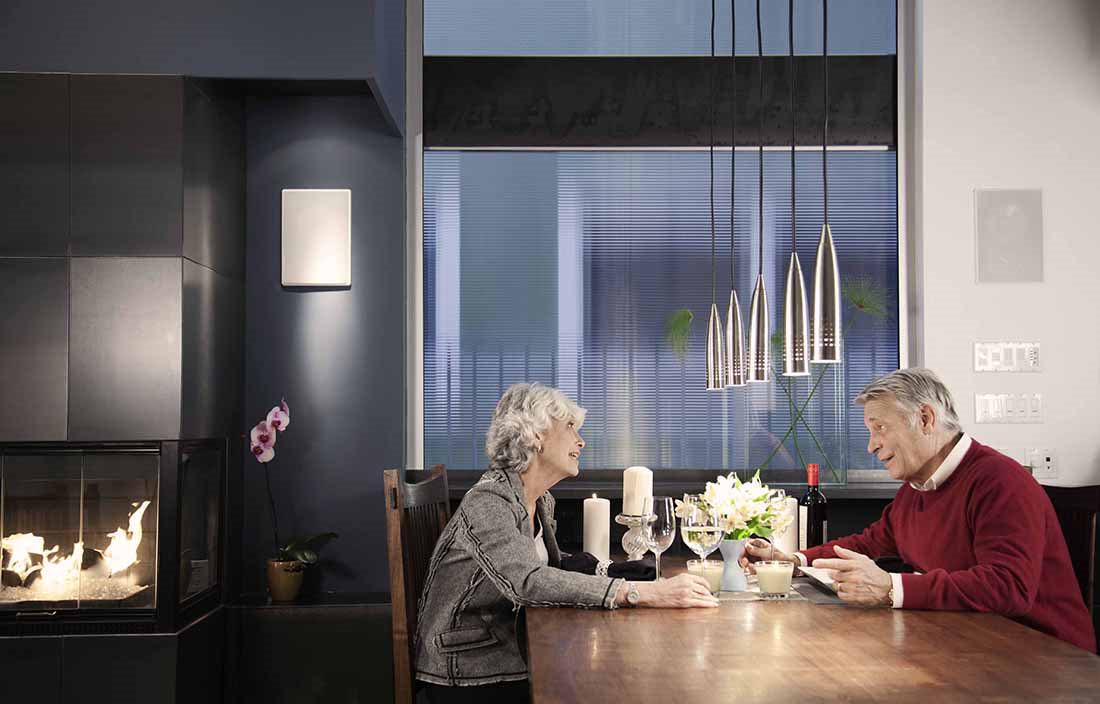 Elderly couple sitting at a dinner table talking.