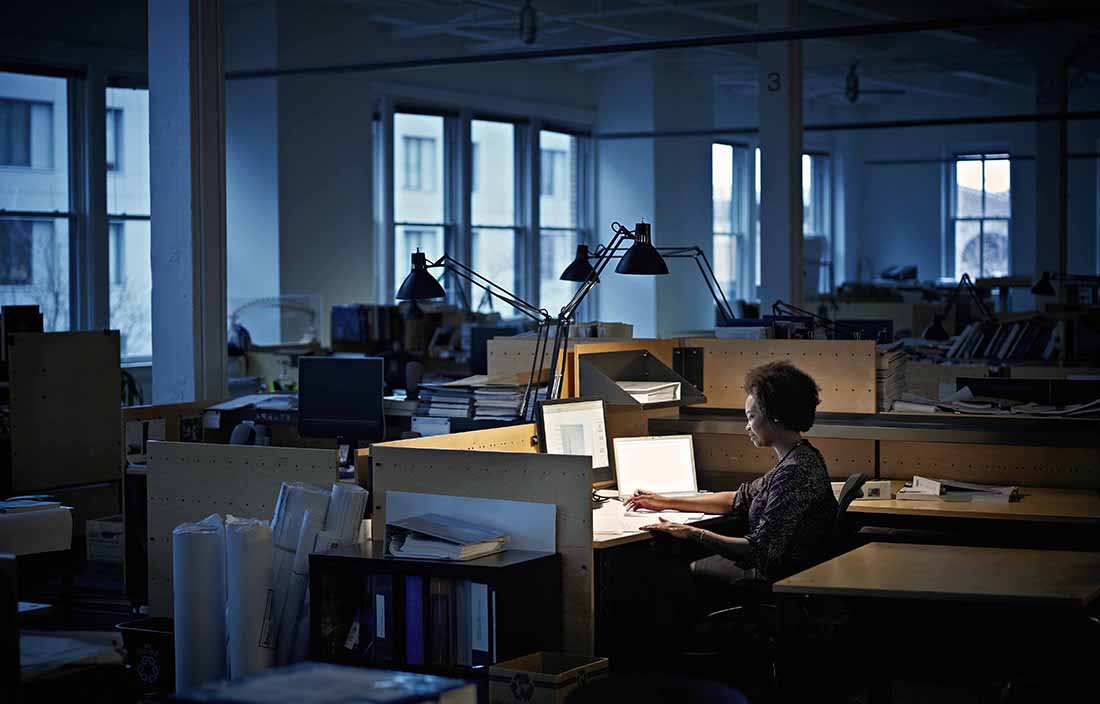 Woman sitting in a dark office on her computer