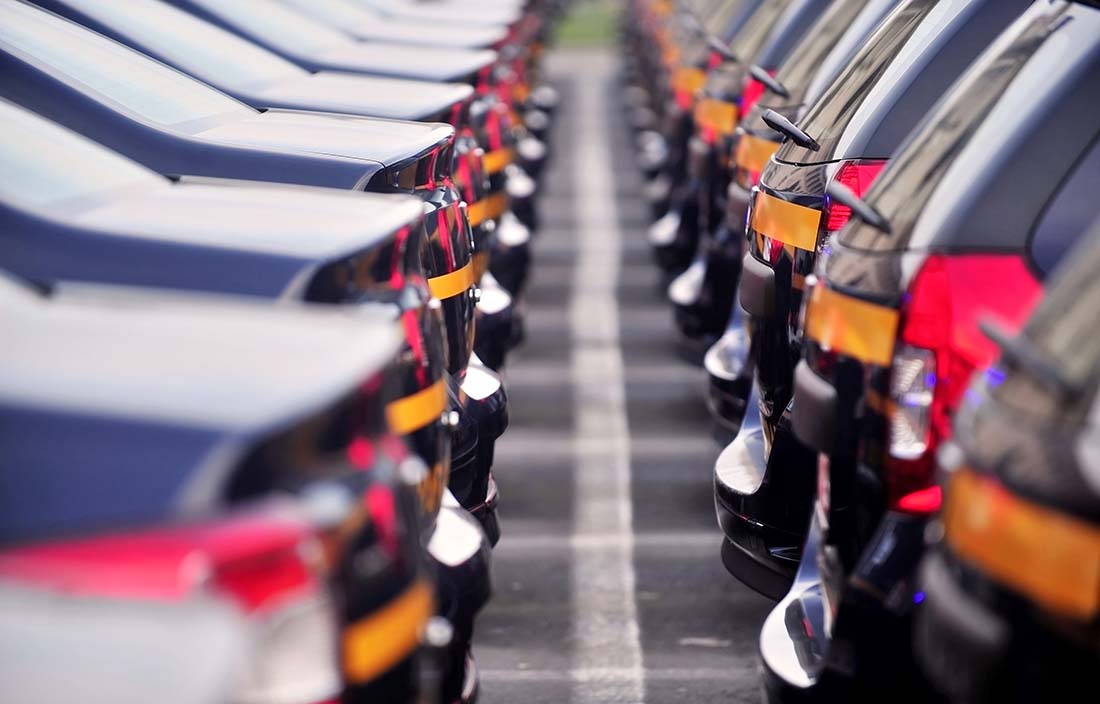 Close-up photo of a row of cars rear bumpers.