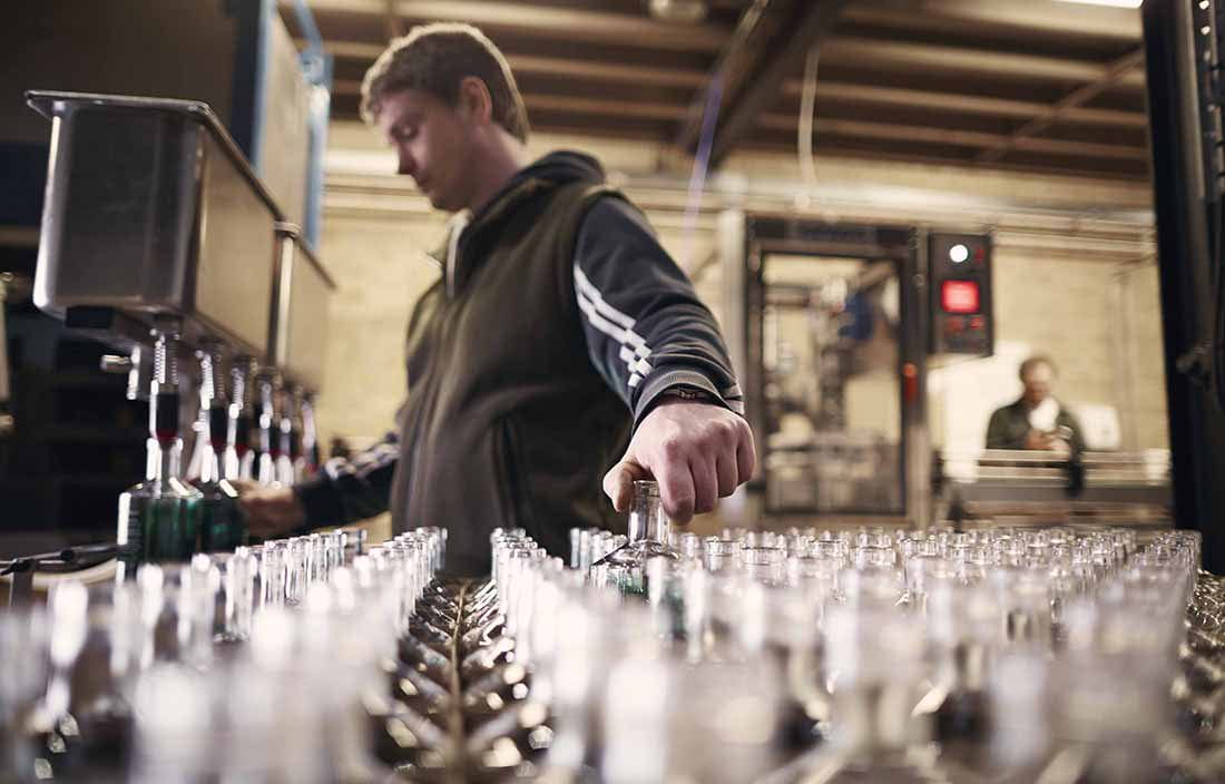 Factory worker working at a glass bottling section.