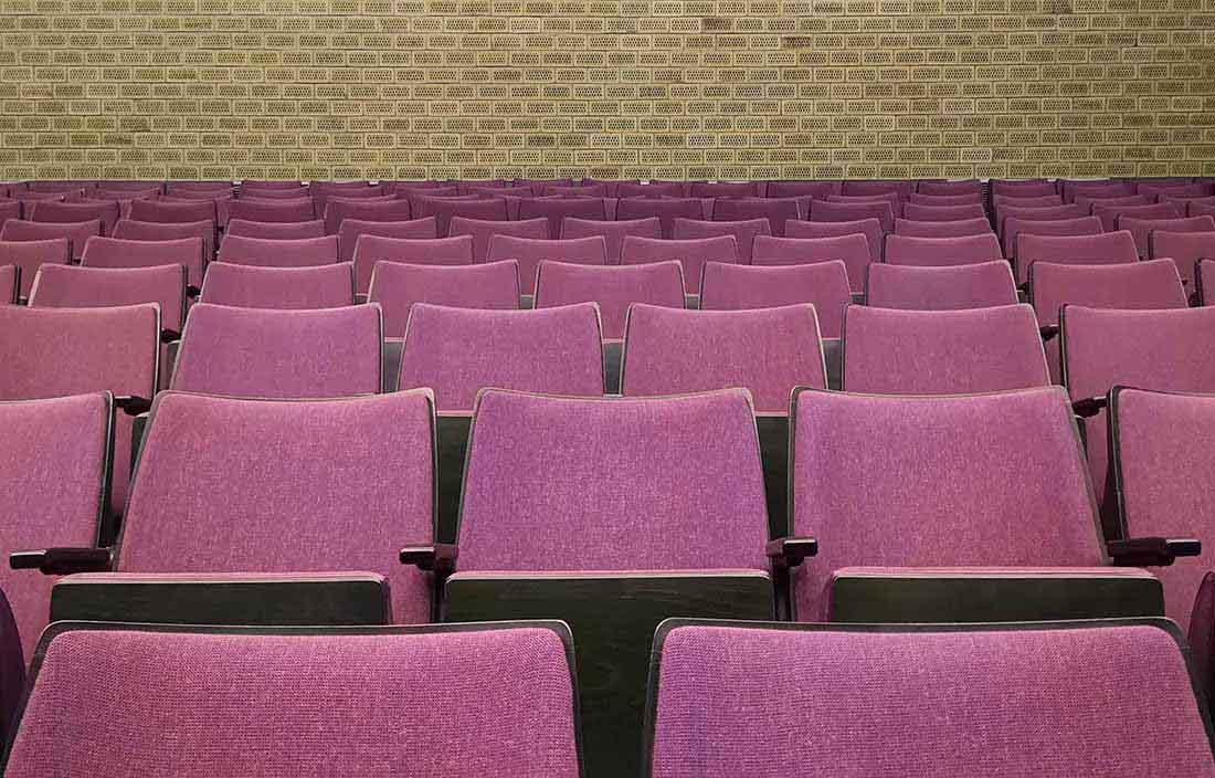 Close-up photo of red auditorium chairs.