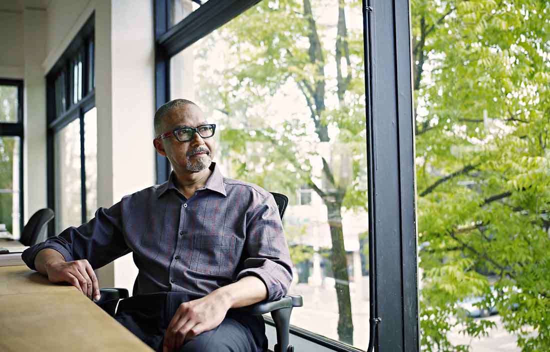 Middle-aged businessperson sitting in a conference room looking out the window.