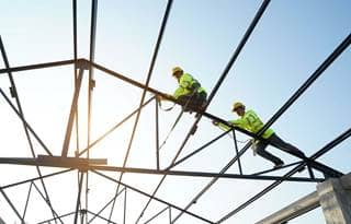 Construction workers on frame of house.