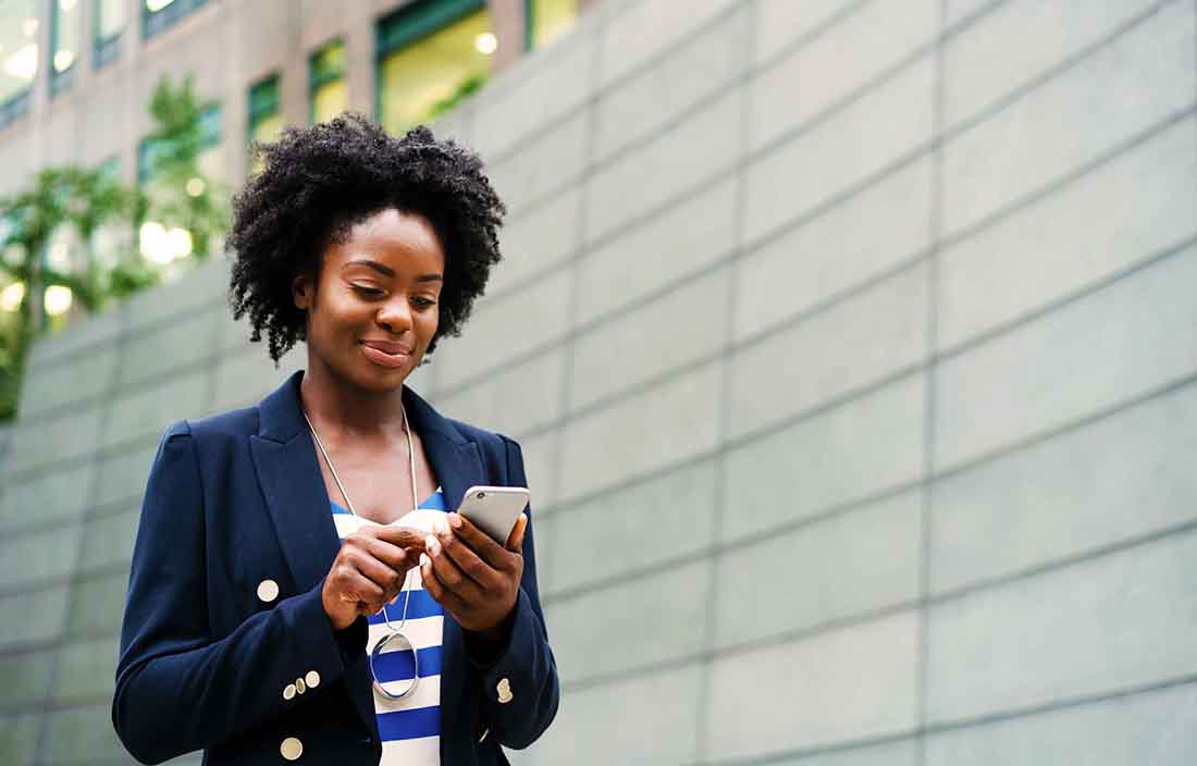 Businessperson checking their phone in an outdoor area.