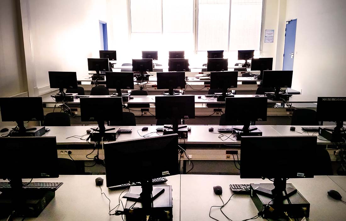 View of an office room with empty desktop computers.