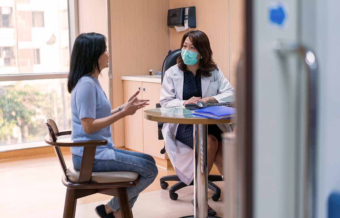 Patient sitting with a doctor at a table discussing medical results.