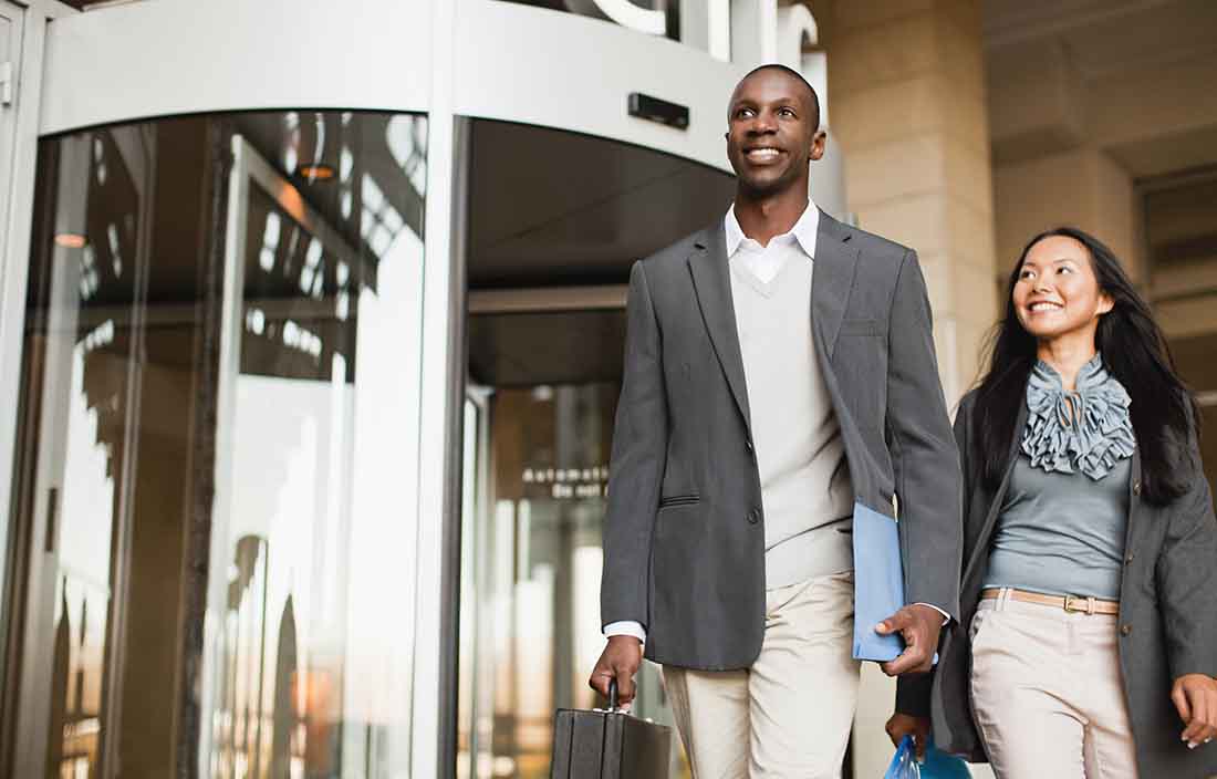 Two business professional walking and smiling.