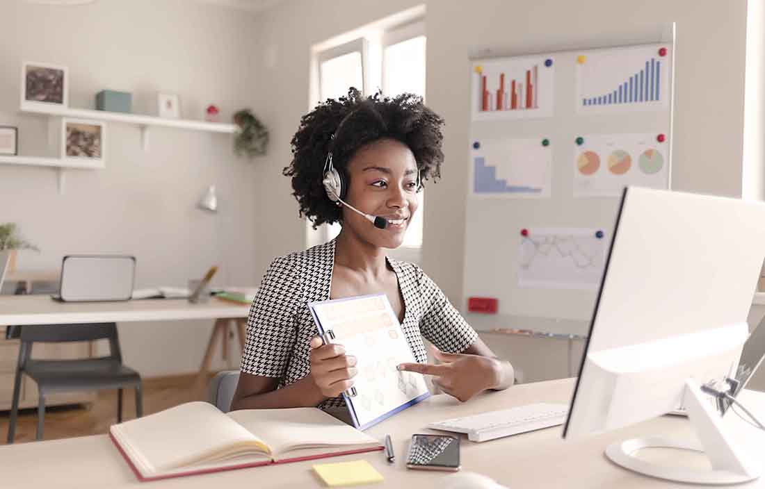 Business professional sitting at a desktop set-up in a modern office.