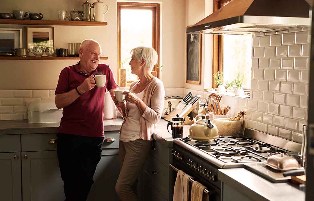 Senior couple in kitchen discussing nursing homes.