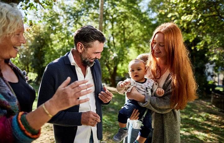 Family smiling and hugging their child.