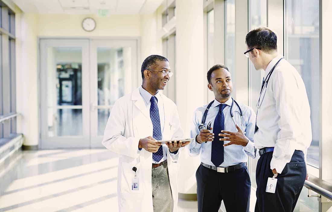 Doctors talking to one another in a hallway.