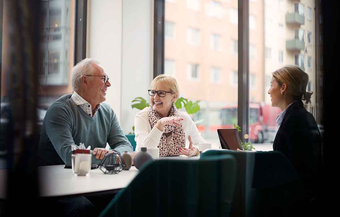 Elderly couple meeting with a business professional in a restaurant for lunch.