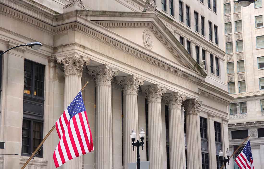 View of an old historical building with two United States of America flags hanging from the building.