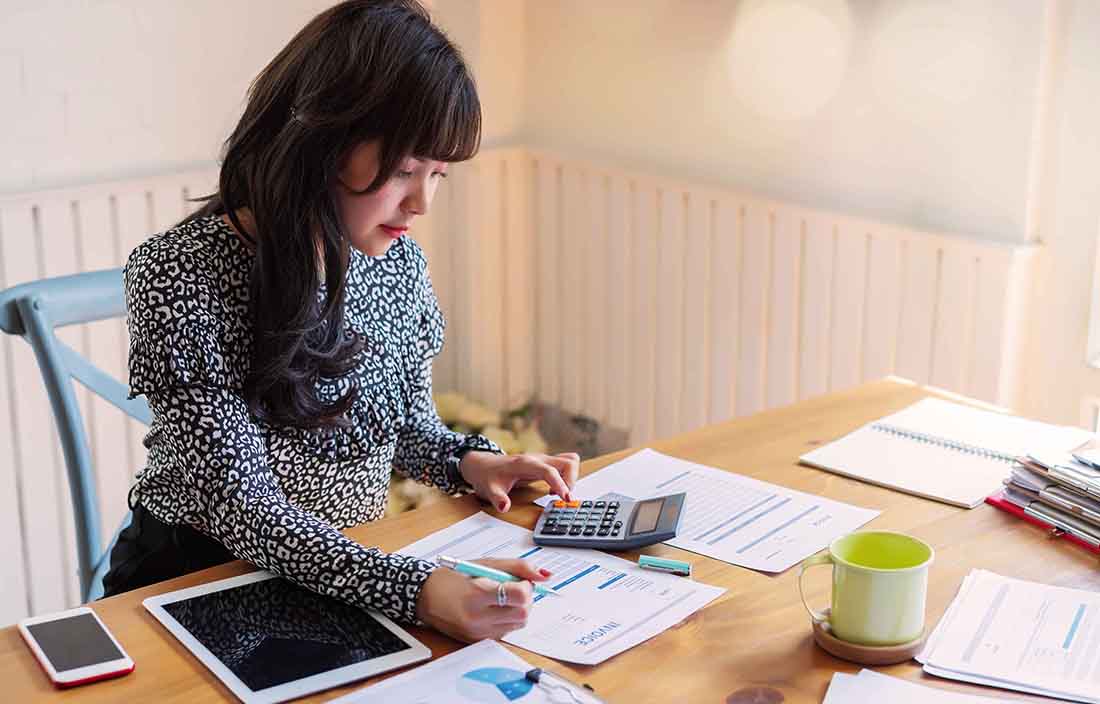 Business professional sitting at her desk reviewing documents.