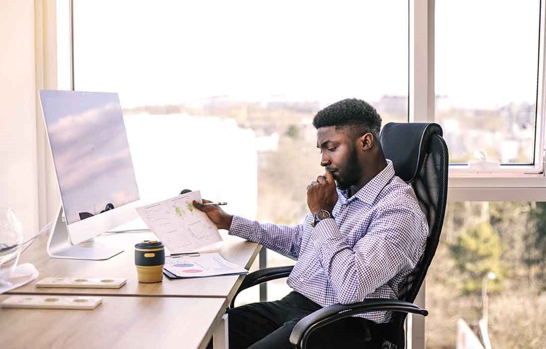 Business professional sitting at their desk reading through some papers.