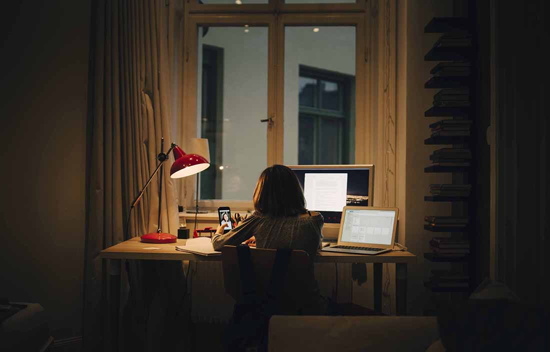 Business professional working at night with a lamp on.