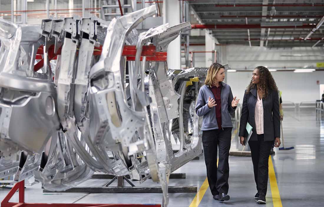Automotive industry consultants walking through a manufacturing facility.