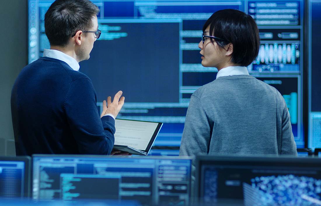 Two business professionals in front of digital analytics dashboards.