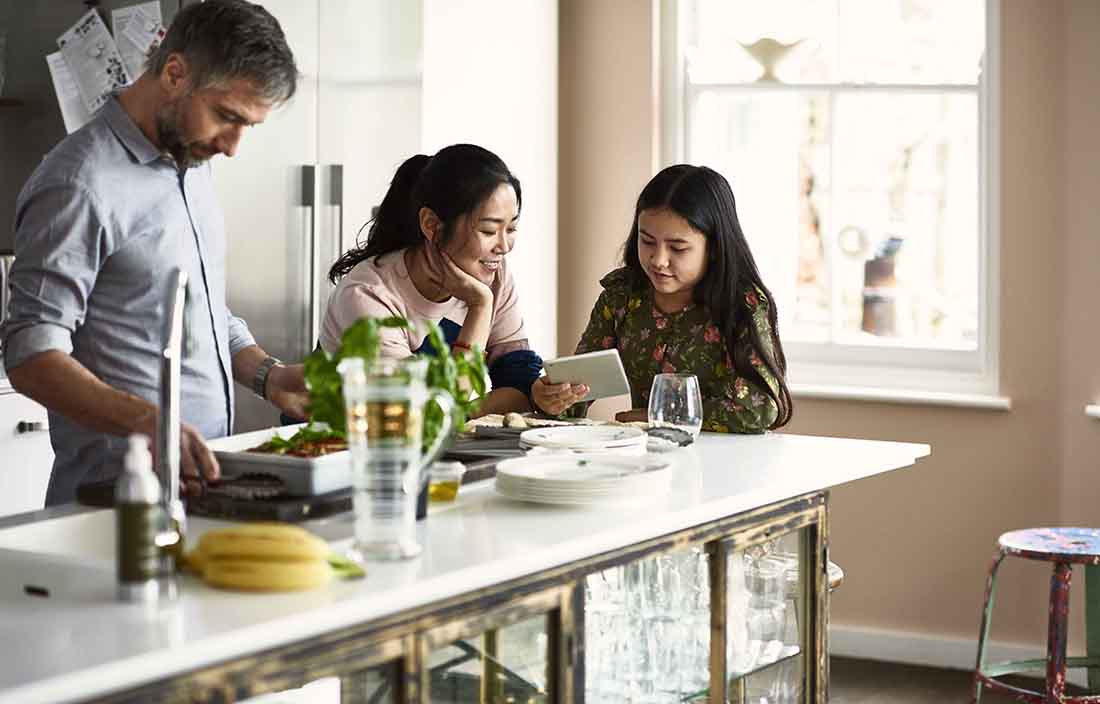 A family sitting at a kitchen table in the morning.