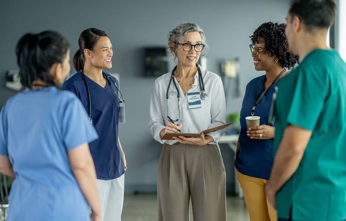 Group of nurses and doctors discussing labor efficiency.