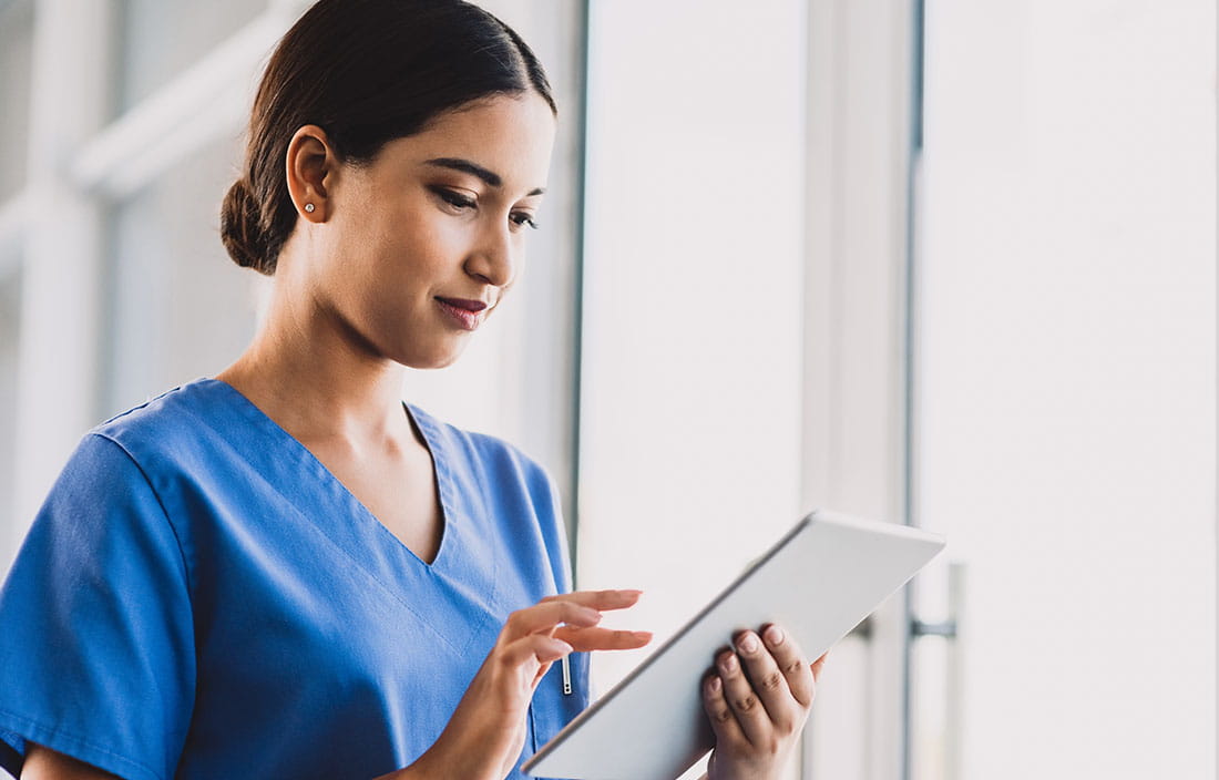 Nurse using a handheld tablet computer.