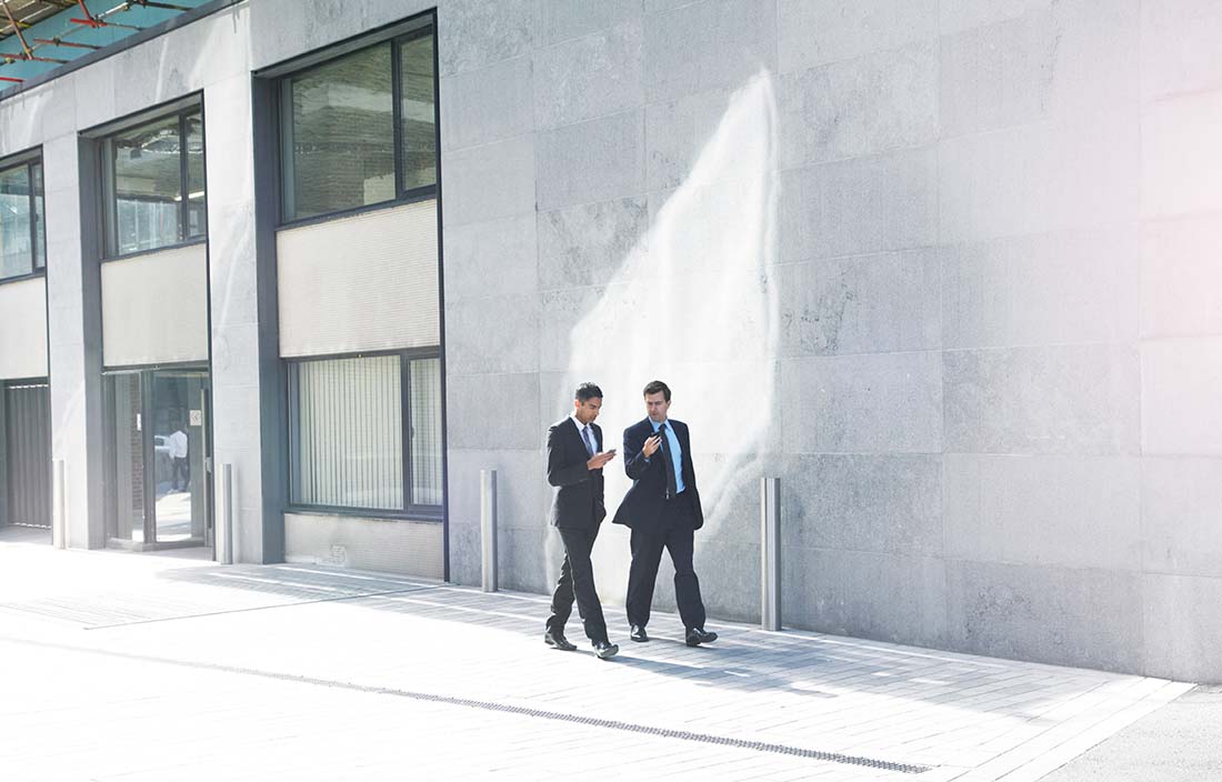 Two businesspeople walking and talking.