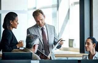 Business professionals looking at a report.